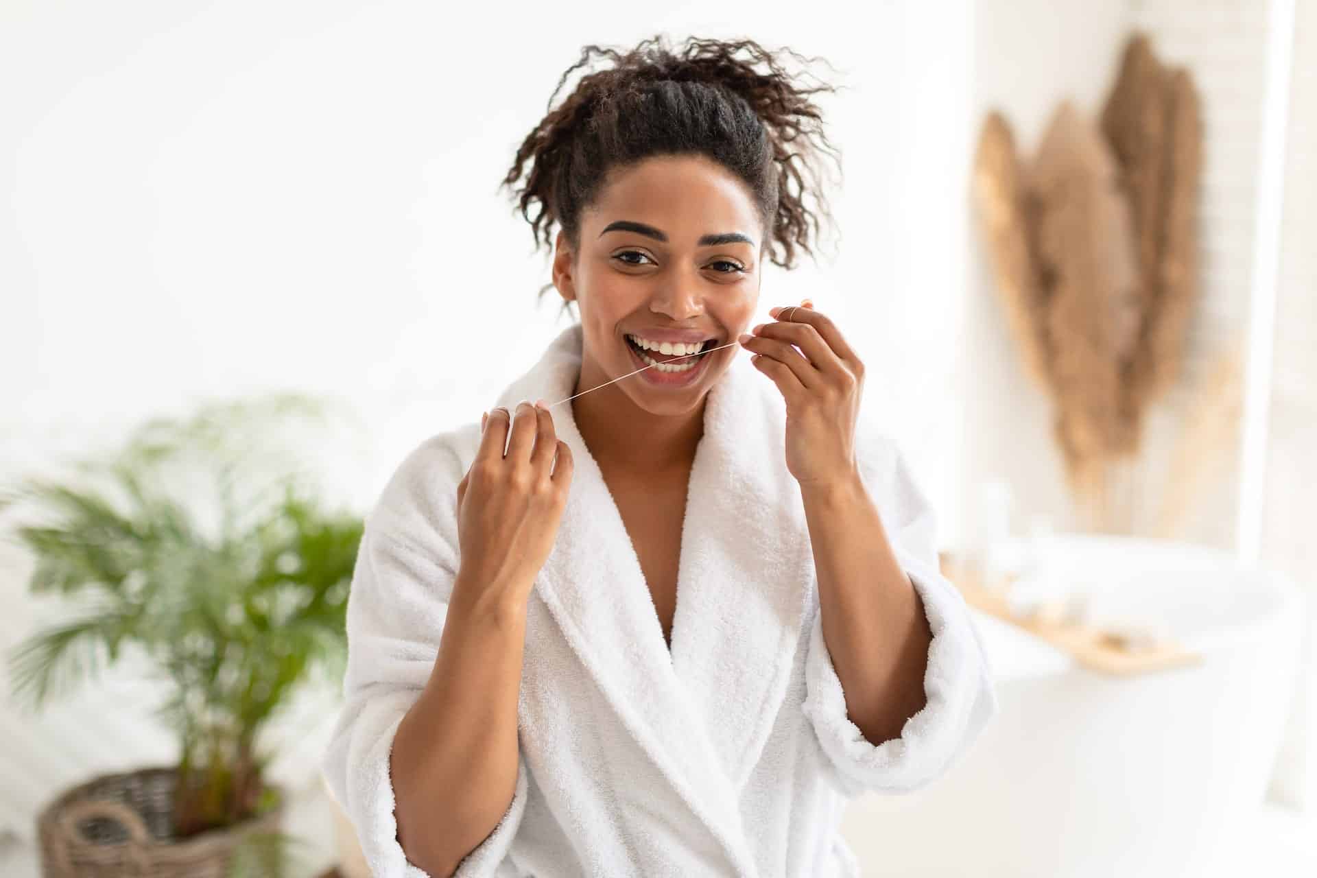 african american woman flossing teeth